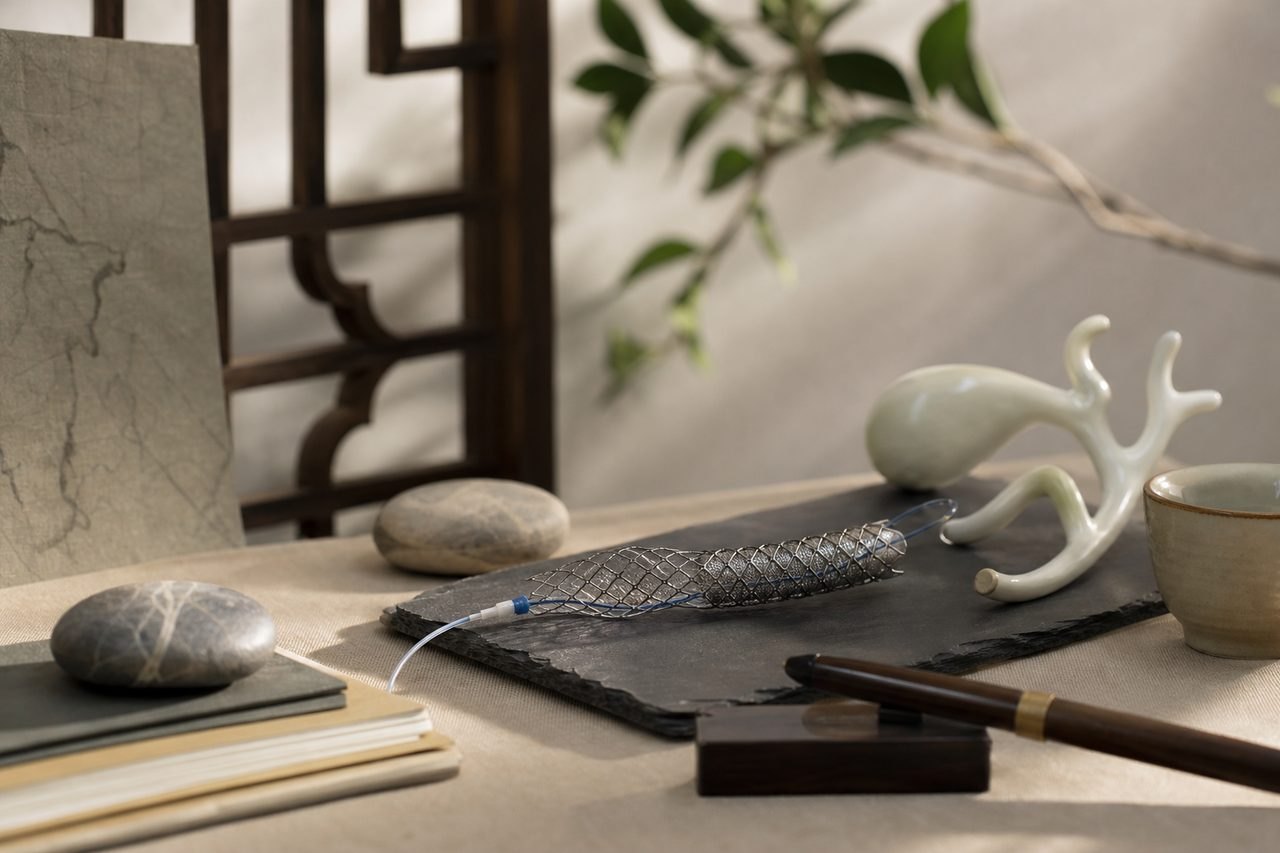 Illustrative image: A serene still life featuring decorative objects, stones, and a medical instrument on a textured surface.