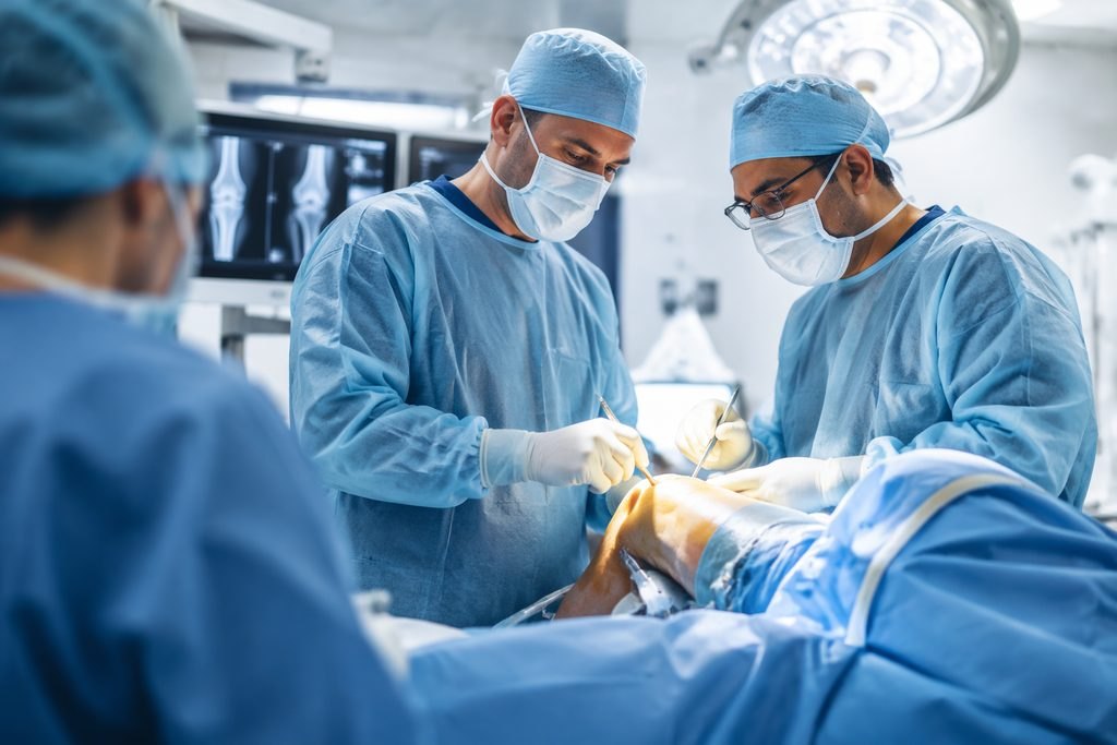 Illustrative image: Surgeons performing a knee surgery in an operating room.