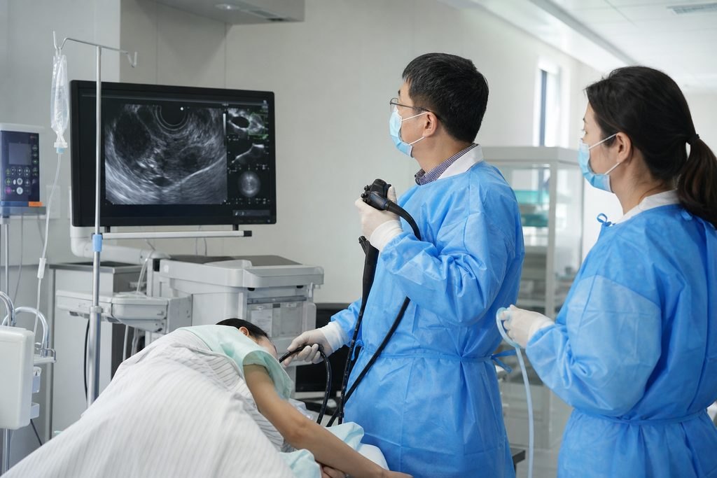 Illustrative image: Medical staff performing an endoscopic procedure with a patient in a clinical setting.