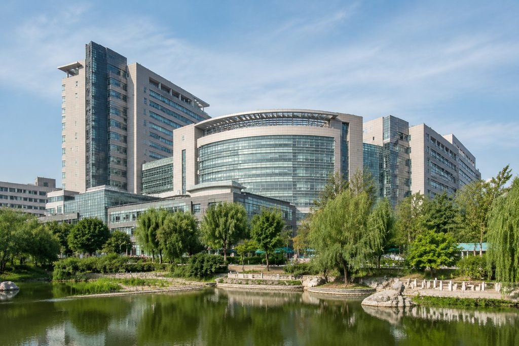 Illustrative image: A modern hospital building surrounded by greenery and a pond.